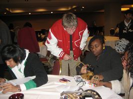 Man in red jacket leading over talking with people at conference