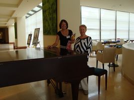 Bozenna and female standing by piano posing for picture